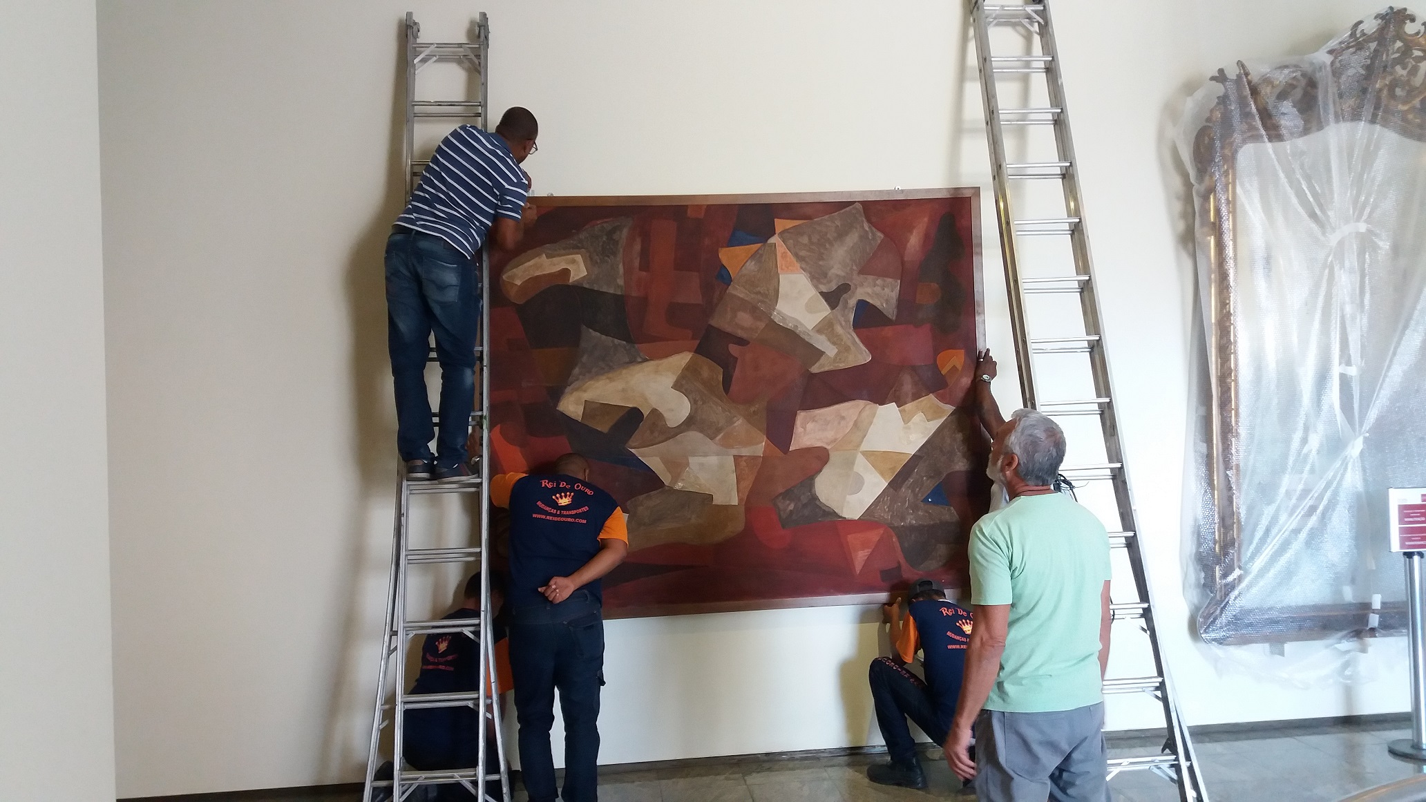 A tela "Fogo" de Portinari sendo fixada na rotunda da exposição de longa duração do MHN